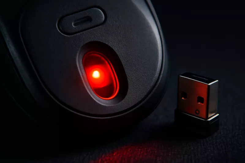 Detalle de sensor óptico en la parte inferior de un ratón inalámbrico